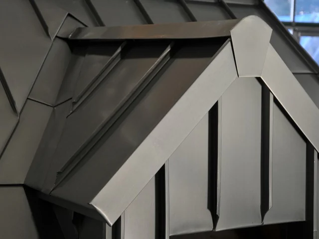 Gaube mit gefalzter Metallbekleidung und Fenster.